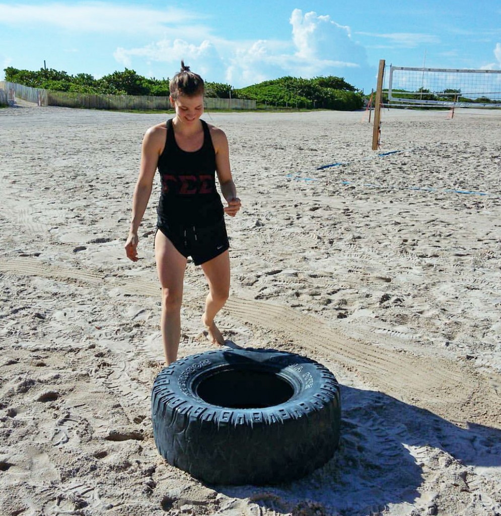 Sarah Smith flips tires on the beach.