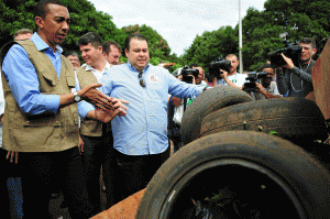 Government officials in Brasilia, Brazil, examine old tires that have collected rainwater and may serve as a breeding ground for mosquitoes. (Photo by Pedro Ventura/Agencia Brasilia)