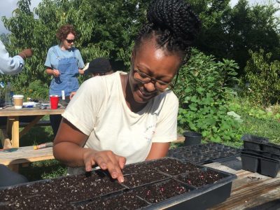 Daijah plants Brussels sprout seeds at Camden Street Learning Garden, a community garden in Raleigh, while volunteering with the Inter-faith Food Shuttle.