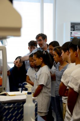 Dr. Steve Meshnick gives refugee high school students a tour of his malaria research lab.