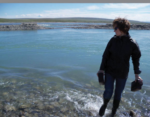 Dr. Rose Cory collects water samples at her field site in the Arctic.