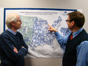 Dr. George Pink (left) and Dr. Mark Holmes review the locations of critical-access hospitals in the United States.