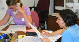 Doctoral students Margaret Adgent and Kim Angelon-Gaetz respond to calls in the state's Public Health Command Center.
