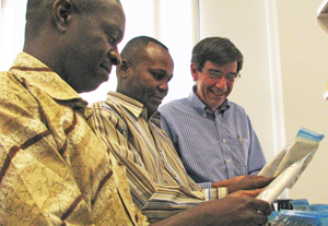 Dr. Steven Meshnick (right) works with Kashamuka Mwandagalirwa (left) and Jeremie Muwonga to sort dried blood-spot samples.