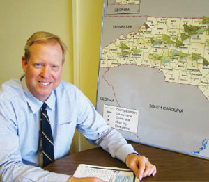 The map beside Dr. Wayne Rosamond shows flags identifying the locations of participating hospitals in the North Carolina Stroke Care Collaborative.