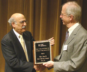 Dr. Bill Zelman (left) accepts the Greenberg Award from health policy and management colleague Dr. John Paul.