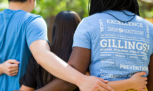 Gillings students with their arms around each other, backs to the camera to show off one student's T-shirt