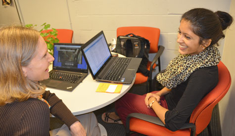 Neha Acharya (right), organizer of the AMWHO conference at the Gillings School, discusses plans with Elizabeth French, liaison to the dean for special initiatives. 