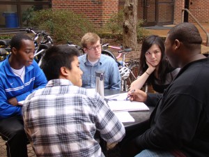 Students share thoughts during a health policy and management class held outside.