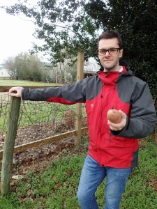 Jed Hinkley holds a sweet potato, one product of the farms and markets he often visits. (Contributed photo)