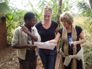Peggy (right) chats with colleagues outside a community nutrition rehabilitation center in Malawi. 