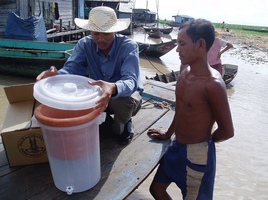 Cambodians examine a ceramic water filter designed by Dr. Mark Sobsey. Photo by Joe Brown.