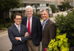 Franklin Farmer, Larry Mandelkehr and Bill Gentry pose outside the UNC Children's Hospital. Mandelkehr and Farmer teach executive master's students how to evaluate health challenges and institute policy changes. Gentry directs the executive master's program. 