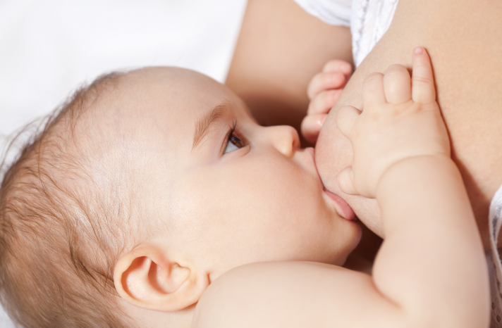 A close-up image of a baby breastfeeding.