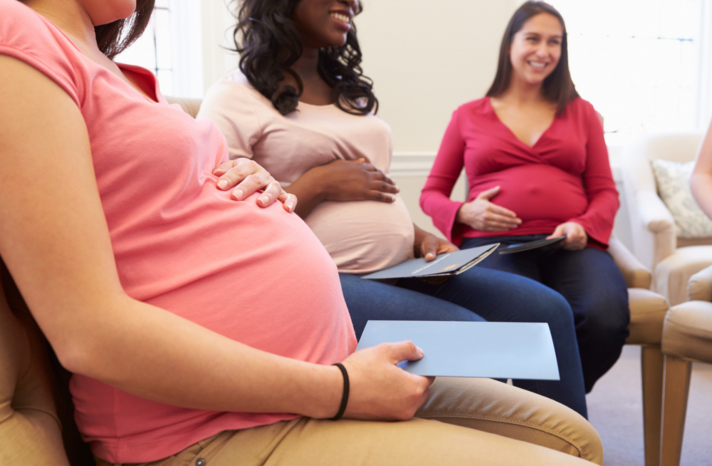 Three pregnant women attend a prenatal education class.