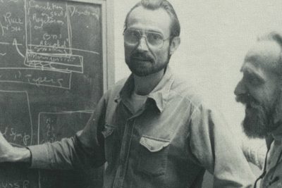 Dr. Gerardo Heiss works an epidemiology problem on a blackboard.