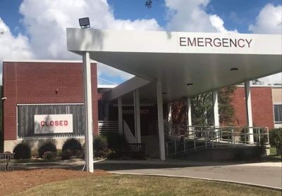 A rural hospital displays a "Closed" sign.