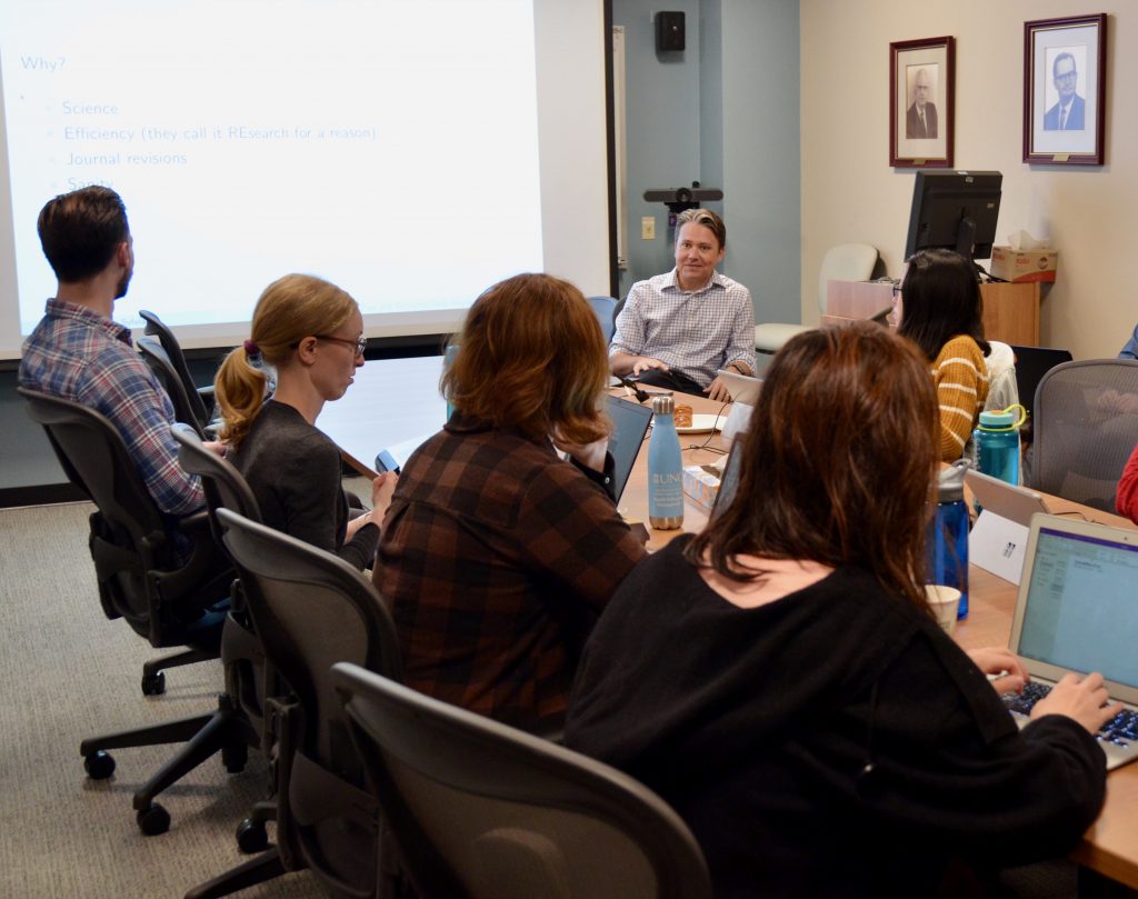 HPM faculty member Sean Sylvia meets with PhD students in the conference room