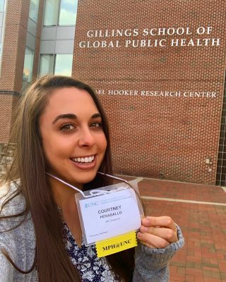 Graduate student Courtney Peragallo shows off her name tag in front of Michael Hooker Research Center.