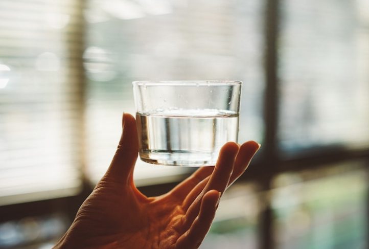 A person holds a glass of water.