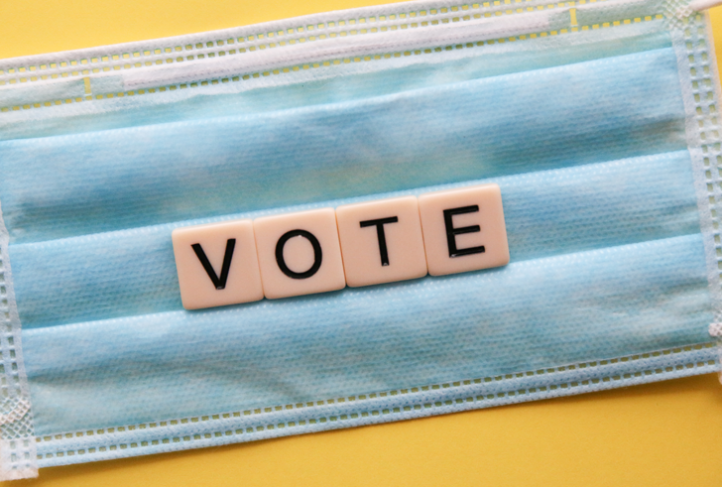 Letters spell out the word 'VOTE' on a surgical mask.
