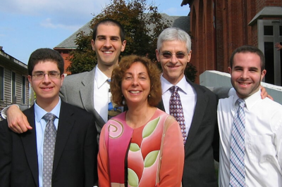 Dr. Michael Aitken (in sunglasses) smiles with his wife and three sons.