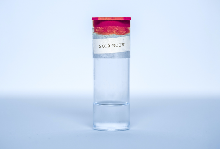 A transparent flask has liquid inside and a 2019-NCOV label taped on it