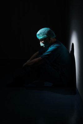 A medical official contemplates life in a dark room.