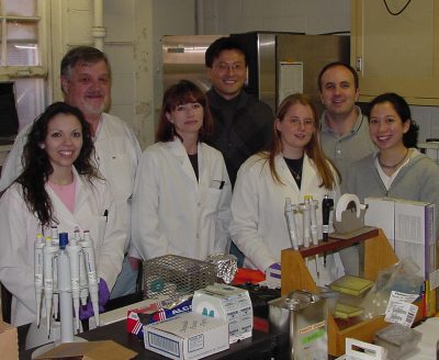 Dr. Fred Pfaender and fellow colleagues gather around lab equipment.
