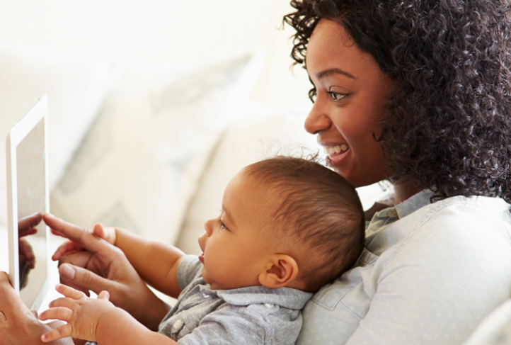 A mom and baby play together on a tablet.