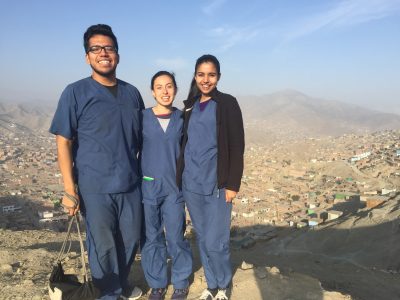 3 interns in medical scrubs standing on hillside