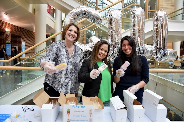L-R: Dean Nancy Messonnier, Kristine Thorne and Sarahi Villa Arreguin hand out LocoPops to celebrate the Gillings School's 2023-2024 rankings results.