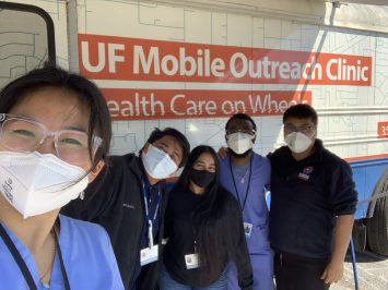 Five members of the clinic team pose in front of the mobile outreach clinic.