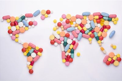 Multicolor pills forming a world map.