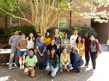 International graduate students pose for a picture outside during a potluck lunch