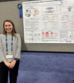 Anastasia Freedman stands by her research poster at the Society of Toxicology meeting