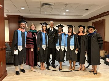 Dean Nancy Messonnier and Surgeon General Vivek Murthy pose with students and faculty at the Gillings School's 2024 Spring Commencement.