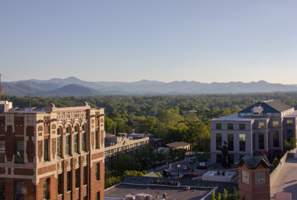 A photo of downtown Asheville with the Blue Ridge Mountains in the horizon.