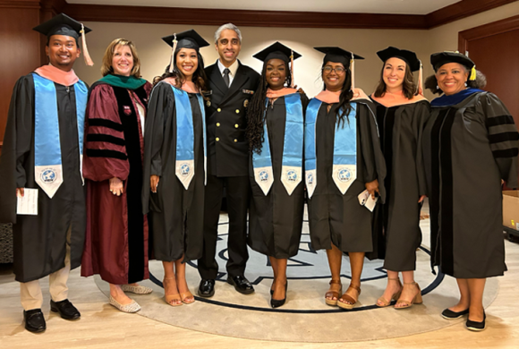 Dean Nancy Messonnier and Surgeon General Vivek Murthy pose with students and faculty at the Gillings School's 2024 Spring Commencement.
